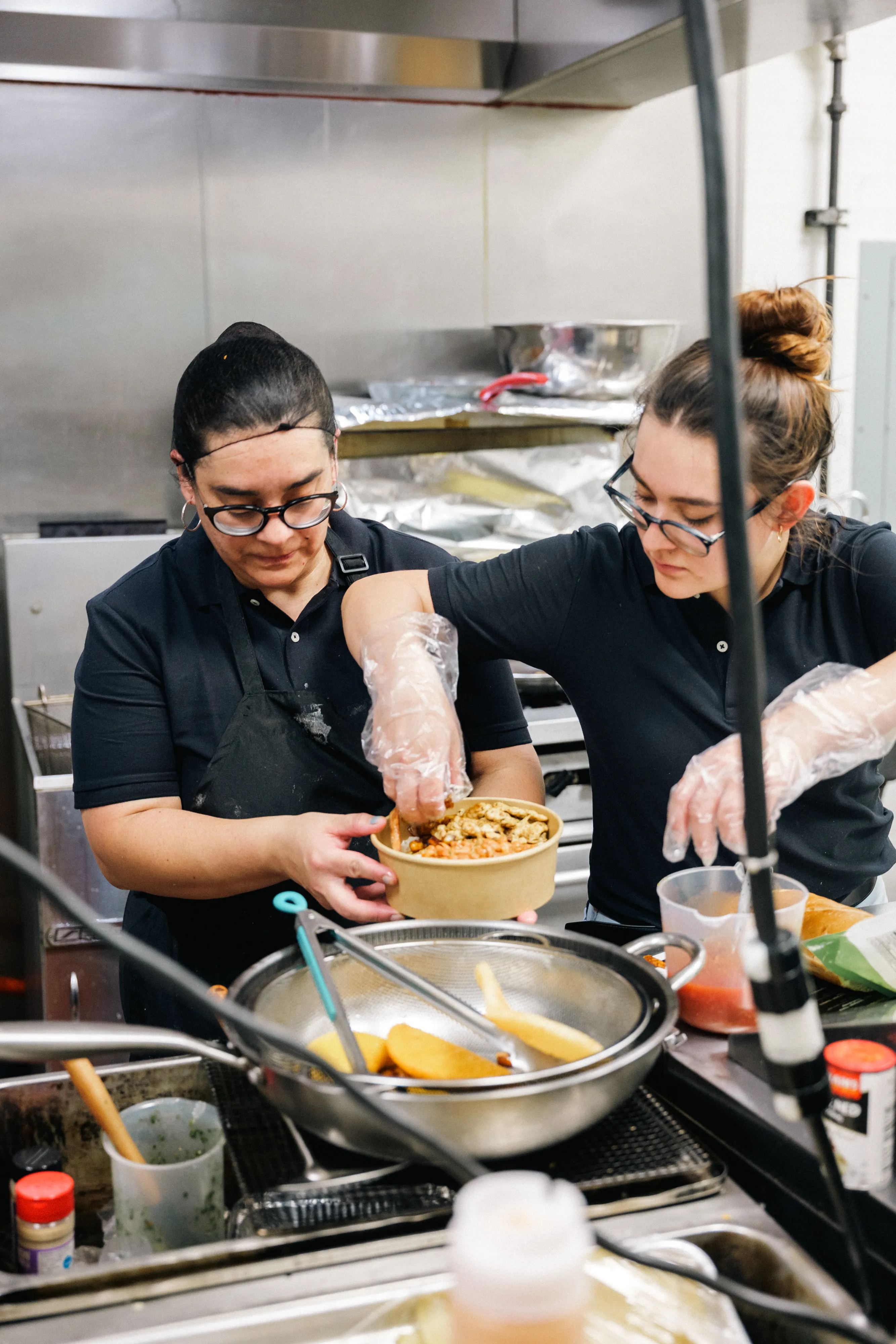 Two Pardito's cooks working side by side on the line, plating an order